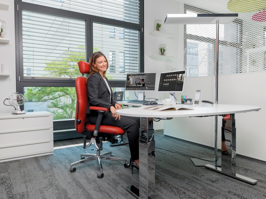 Frau sitzt auf B&uuml;rostuhl Bioswing 450 in rotem Leder am Schreibtisch