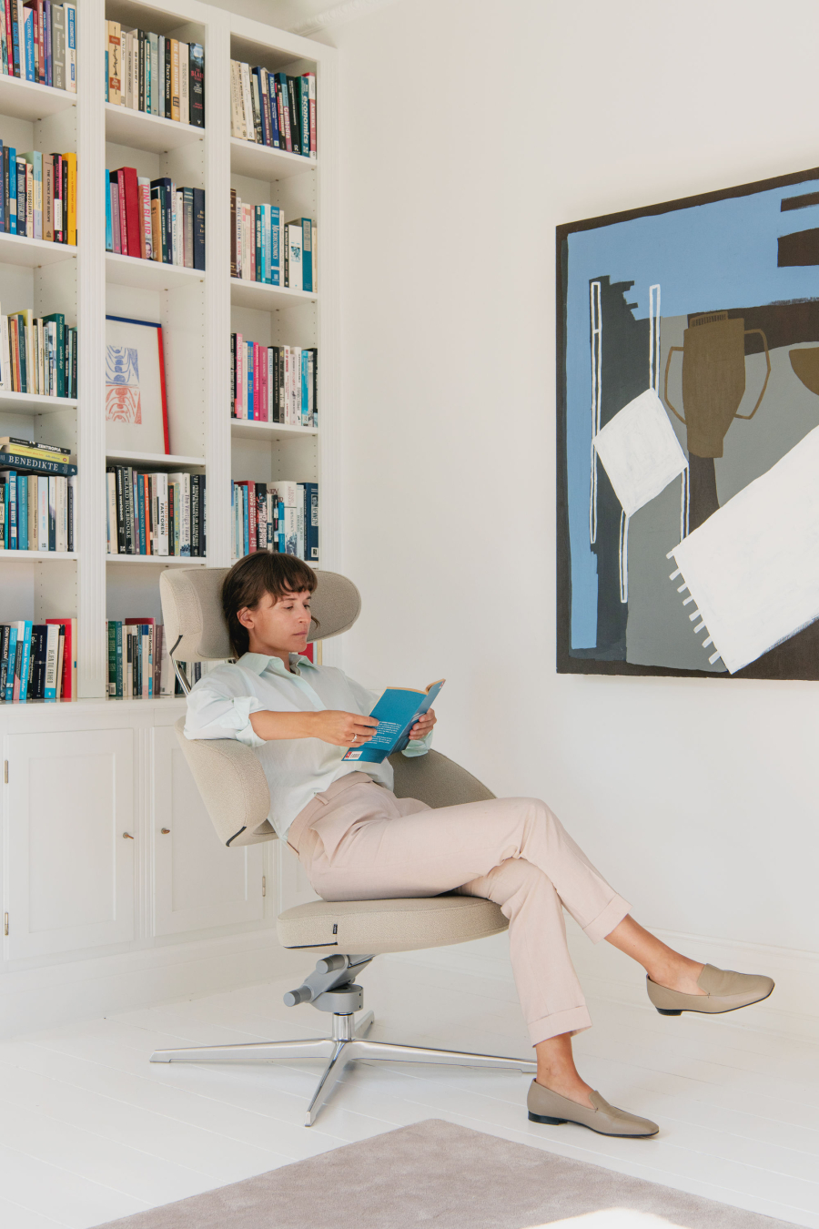 Frau sitzt auf Peel Sessel liest entspannt ein Buch
