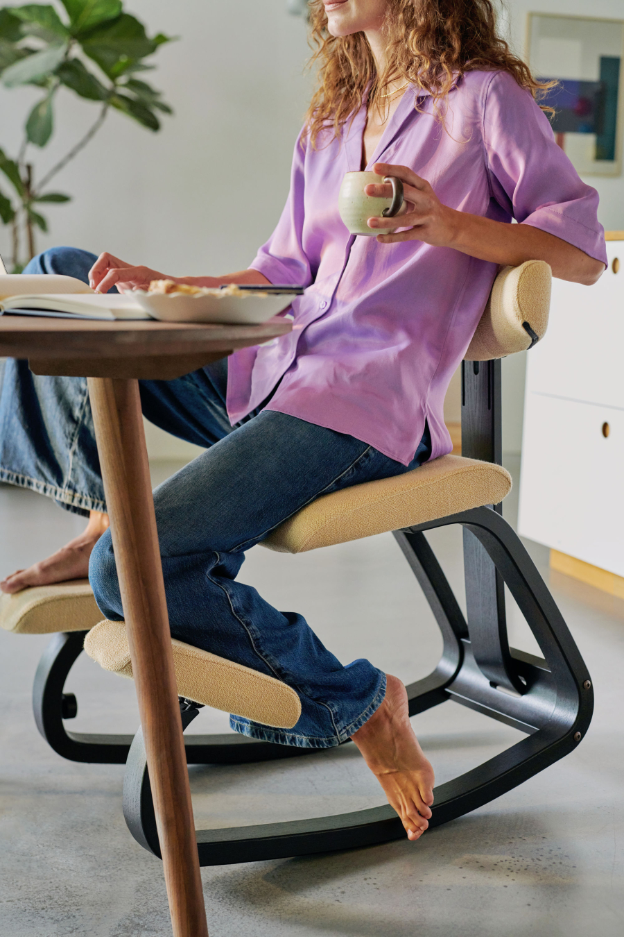 Frau entspannt beim Sitzen auf dem Kufenstuhl Stokke Thatsit