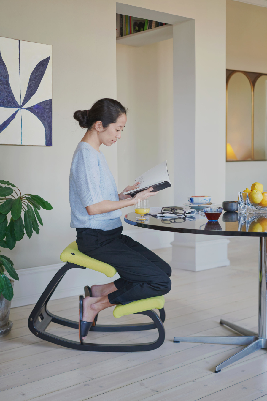 Frau sitzt auf Variable Balansstuhl liest ein Buch